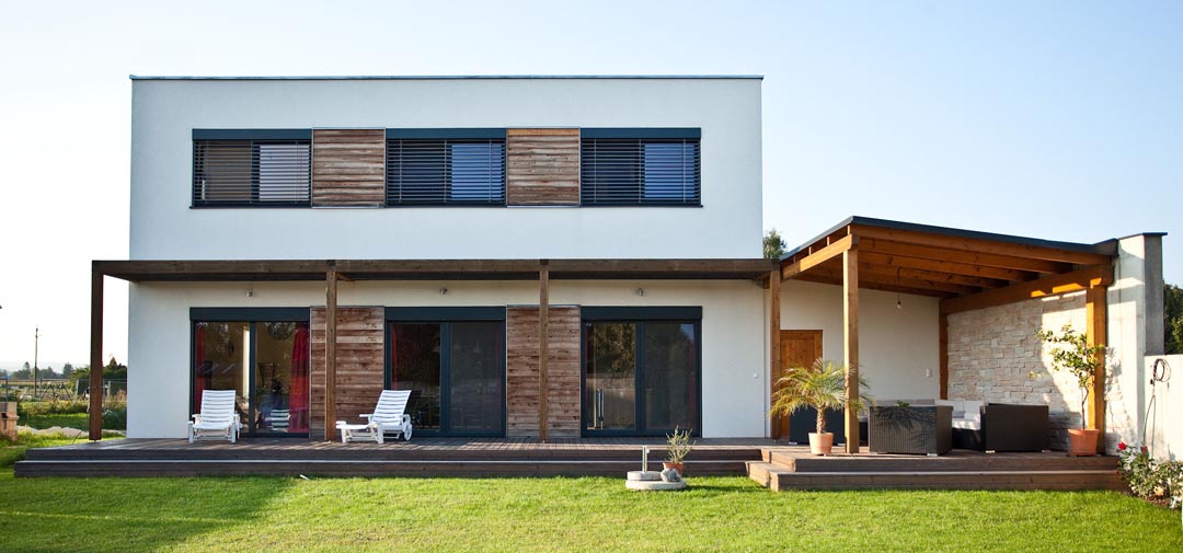 Real two-storey prefabricated house with flat roof, timber accents and large glazed openings