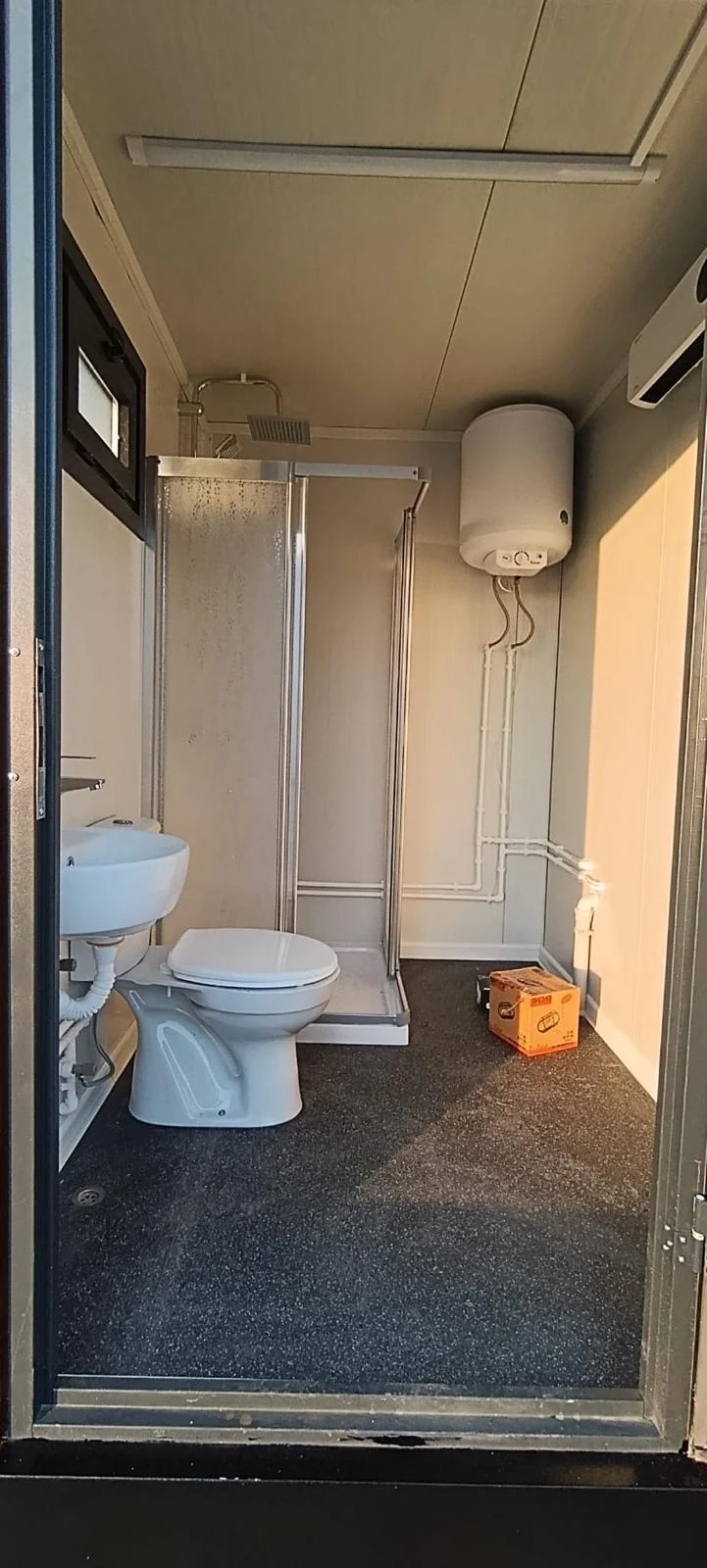 Combined modular bathroom with WC, basin, shower enclosure and wall-mounted water heater