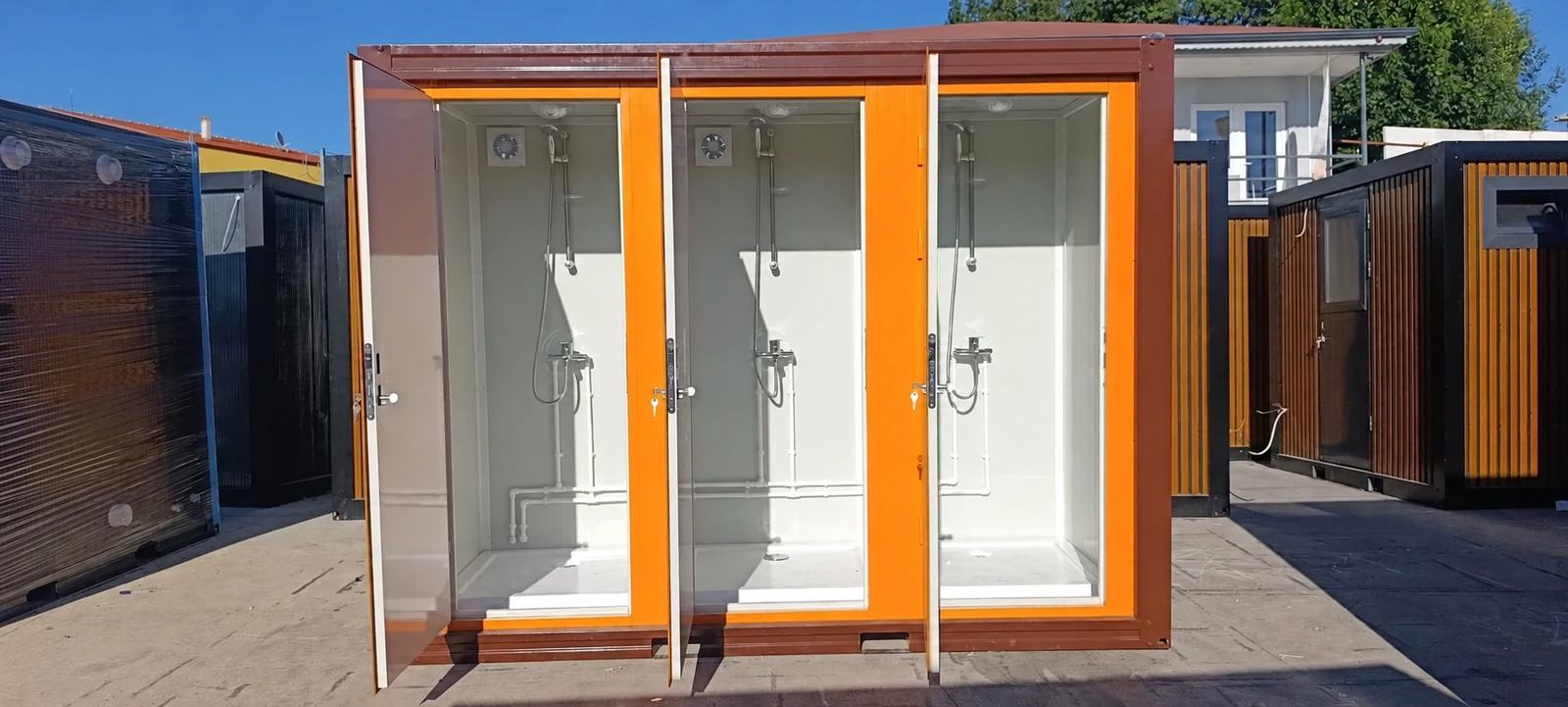 Open shower block with individually accessed shower compartments, trays, mixers and ventilation fans